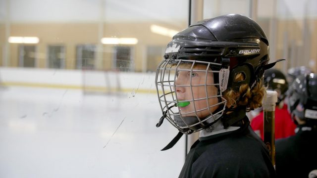 A student watches from behind the glass
