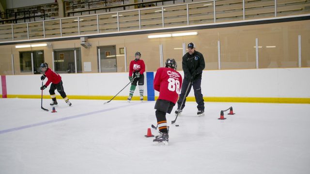 David Cullen guiding a student through a skating drill